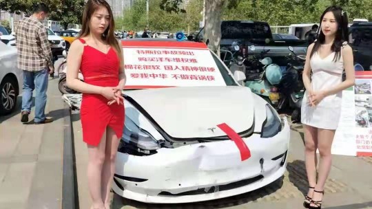 安阳特斯拉车顶维权女孩  在郑州国际车展亮相事故车维权